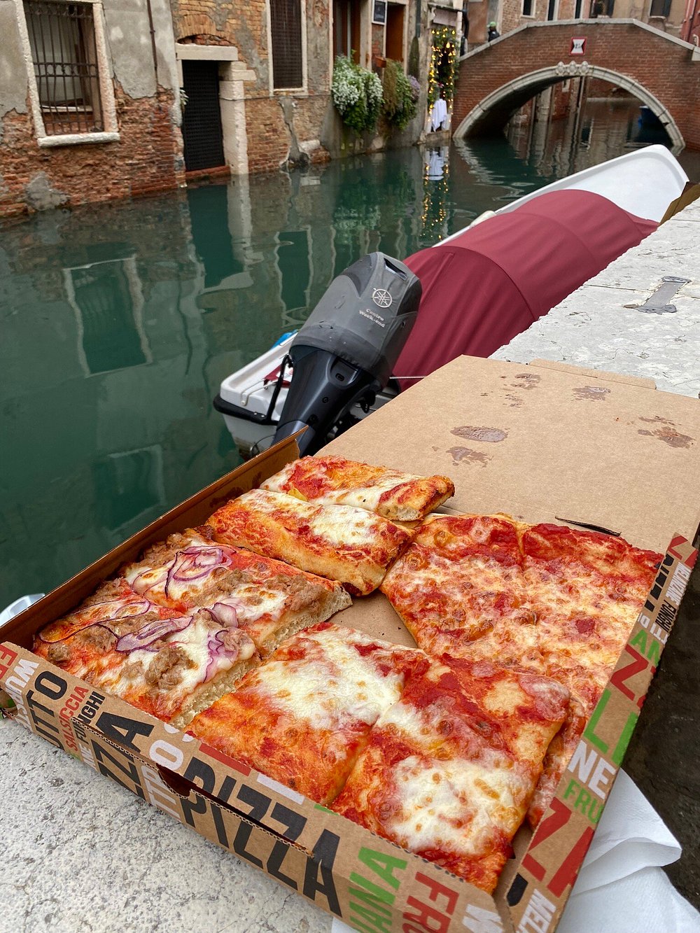 Tranci di pizza appena tagliati e disposti sul banco della pizzeria.