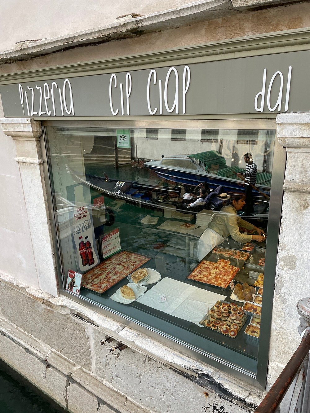 Insegna e vetrina esterna della pizzeria in una calle veneziana.