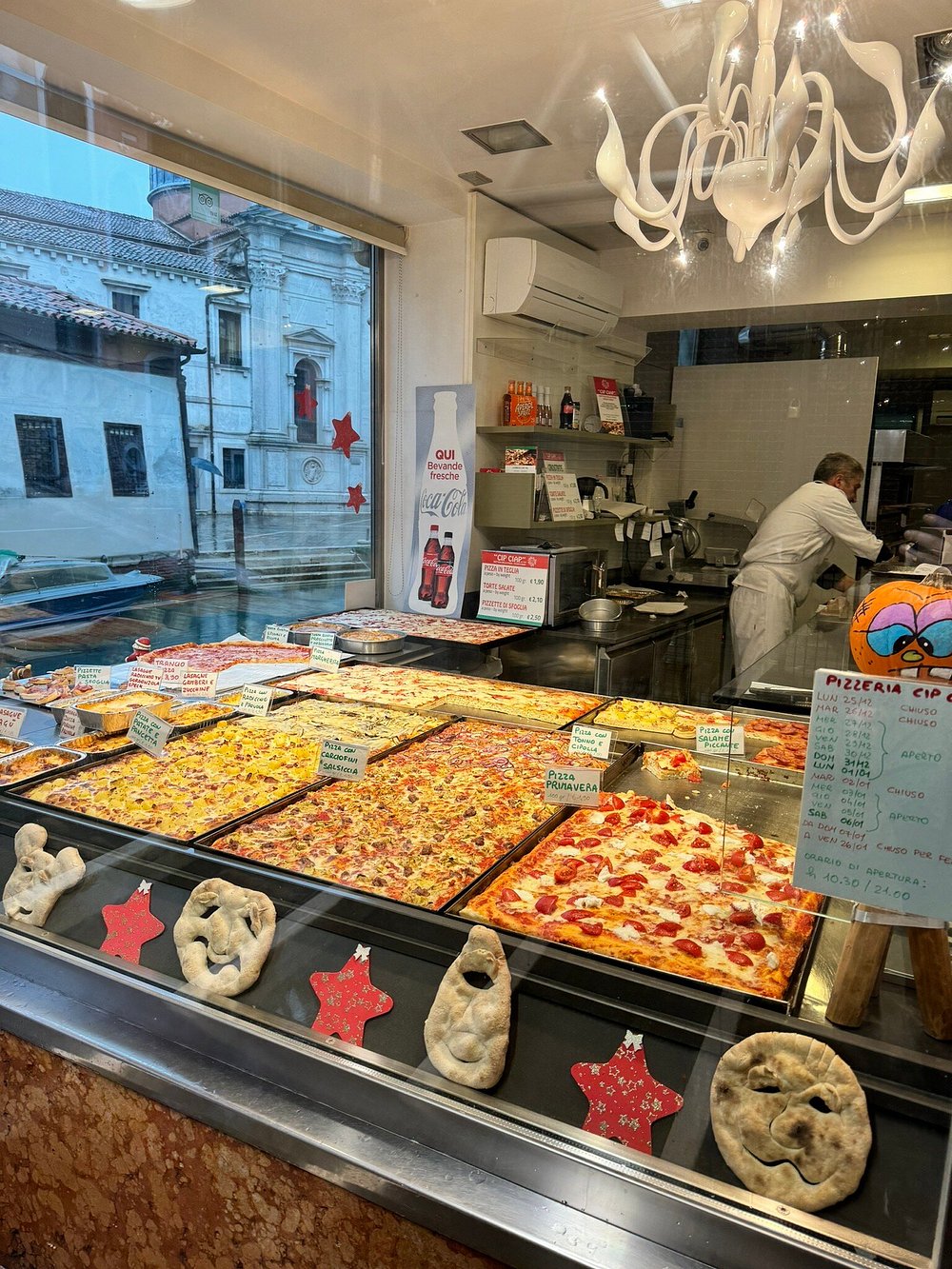 Vetrina esterna della Pizzeria Cip Ciap con le teglie di pizza ben visibili.